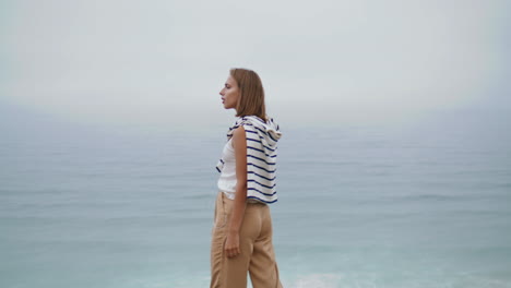 Ocean-girl-listening-music-at-beautiful-cliff-vertical.-Attractive-woman-relax