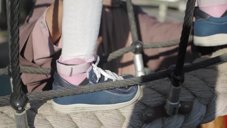 toddler climbing on a rope playground structure