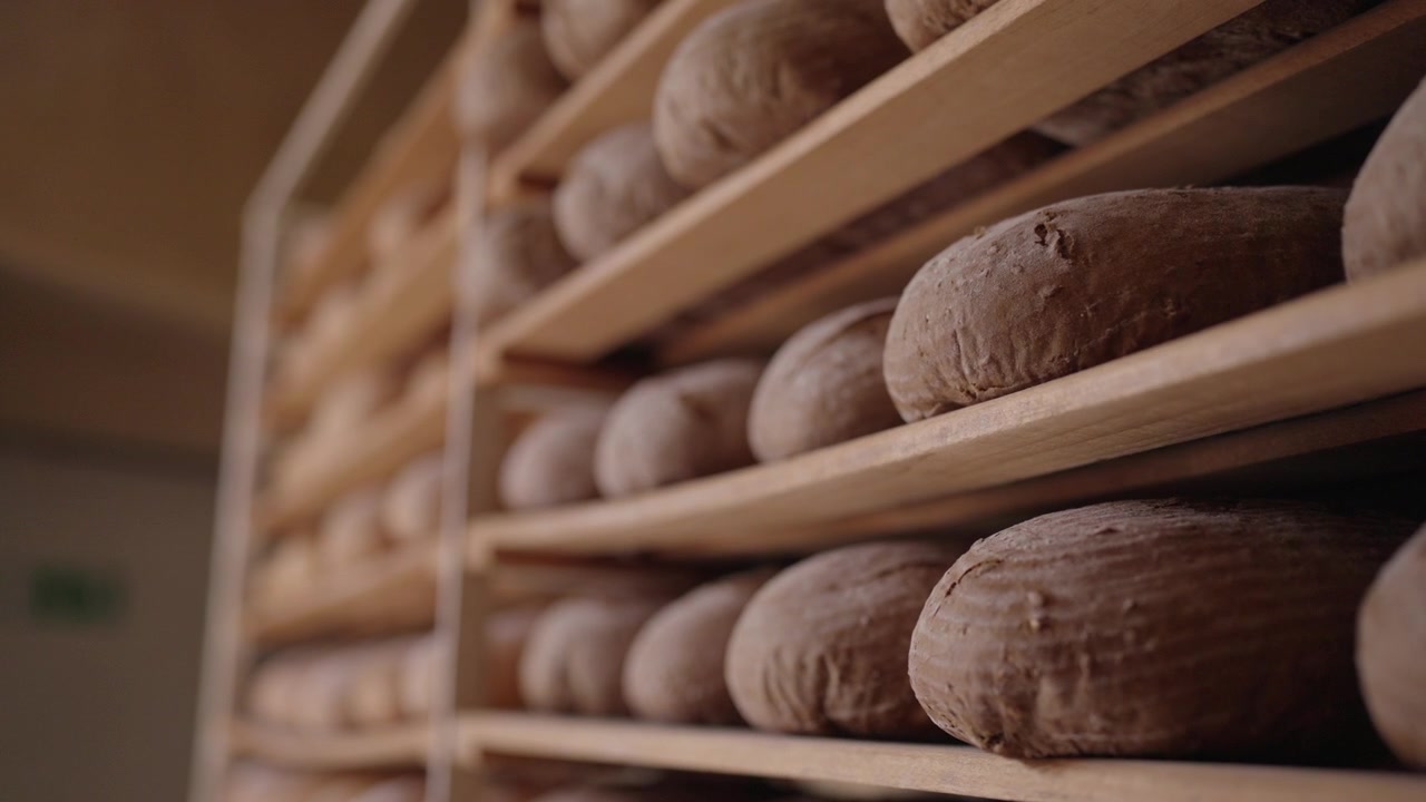File di pagnotte di pane fresco che si raffreddano sugli scaffali di una panetteria.