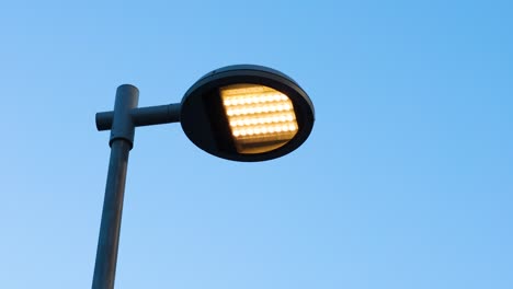 una luz de la calle se ilumina contra un cielo despejado