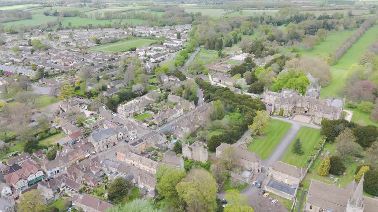 Sweeping aerial of historic market town where Corsham Court’s stately manor, tree-lined high street and surrounding countryside illustrate rural heritage blended with community living