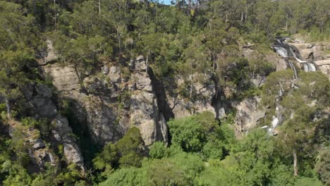 forward moving aerial shot of a deep canyon leading to a waterfall in the bush of australia