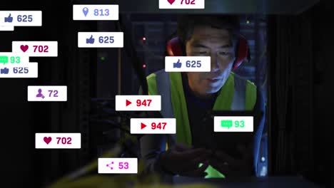 Animation-Von-Social-Media-Symbolen-Und-Zahlen-über-Einem-Asiatischen-Männlichen-IT-Techniker-Durch-Einen-Computerserver