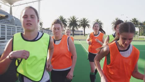 female hockey players warming up on the field