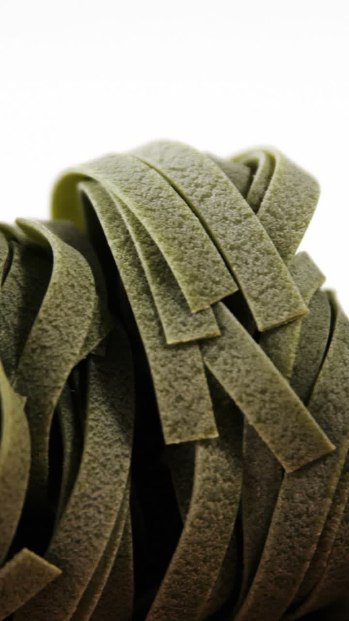 fideos de fettuccine de espinaca y cebolla sobre fondo blanco