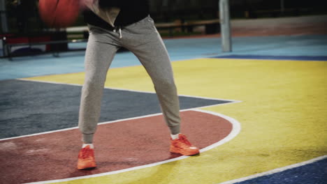 Nahaufnahme-Einer-Basketballspielerin,-Die-Nachts-Mit-Ball-Auf-Dem-Außenplatz-Trainiert