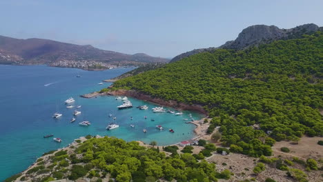 ascending drone shot of moored yachts and catamarans on a beautiful bay for diving