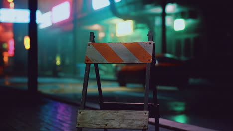 urban construction barrier stands illuminated by neon signs at night