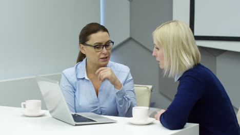 dos mujeres de negocios trabajando en una computadora portátil