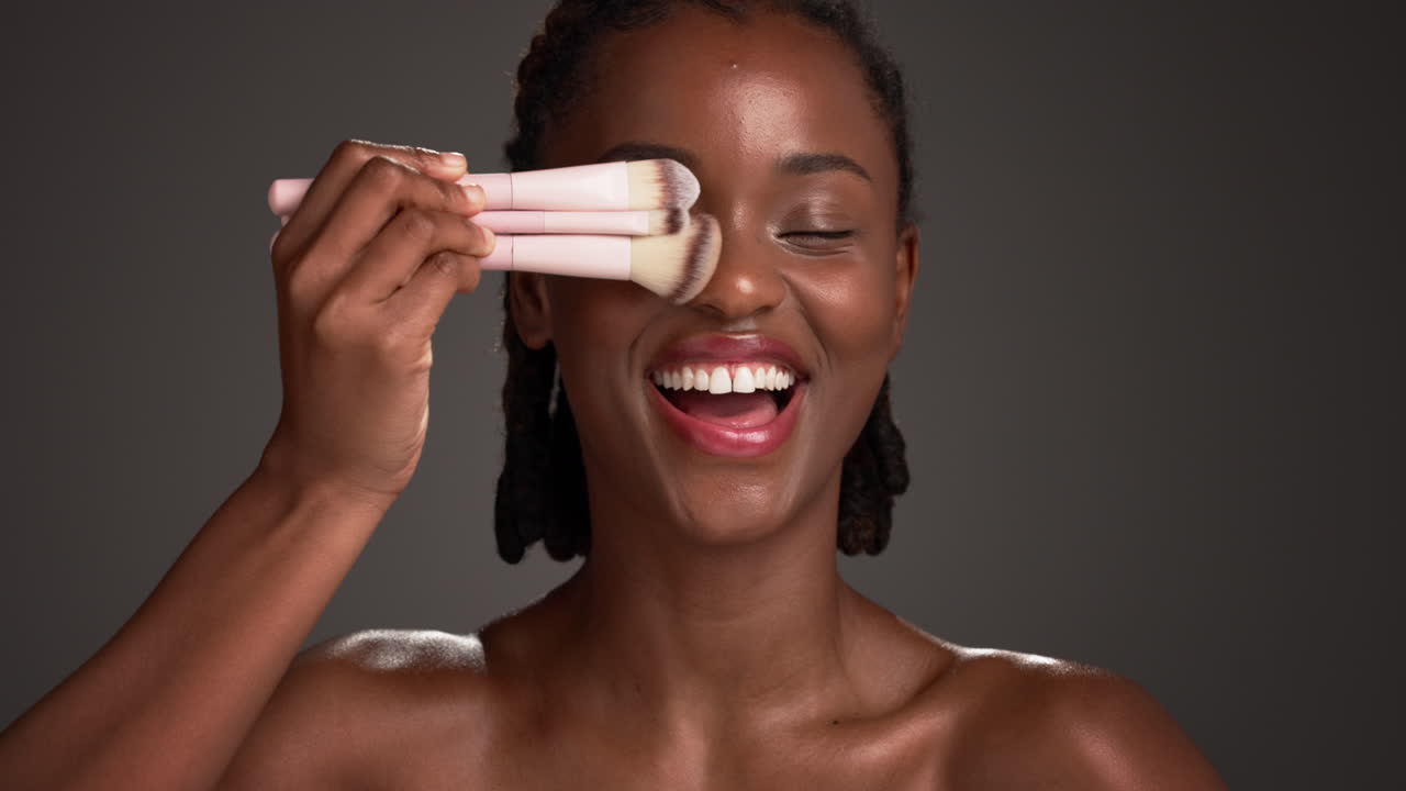Woman with makeup brushes covering eye