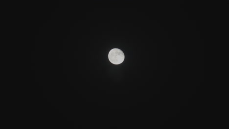 toma estacionaria desde la tierra de una luna llena en una oscura noche de verano en ventura beach en el sur de california
