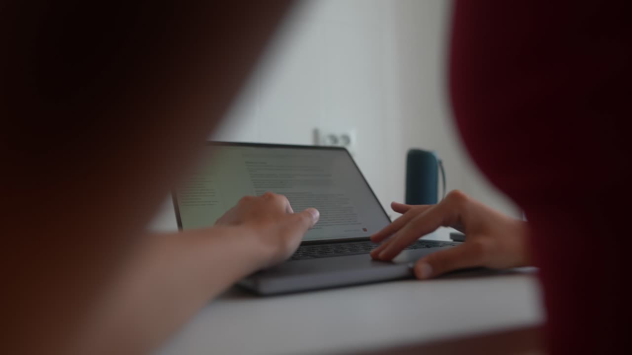 Close-up of Hands Typing and Scrolling on a Laptop