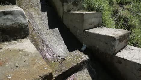 water flowing through a stone and concrete canal