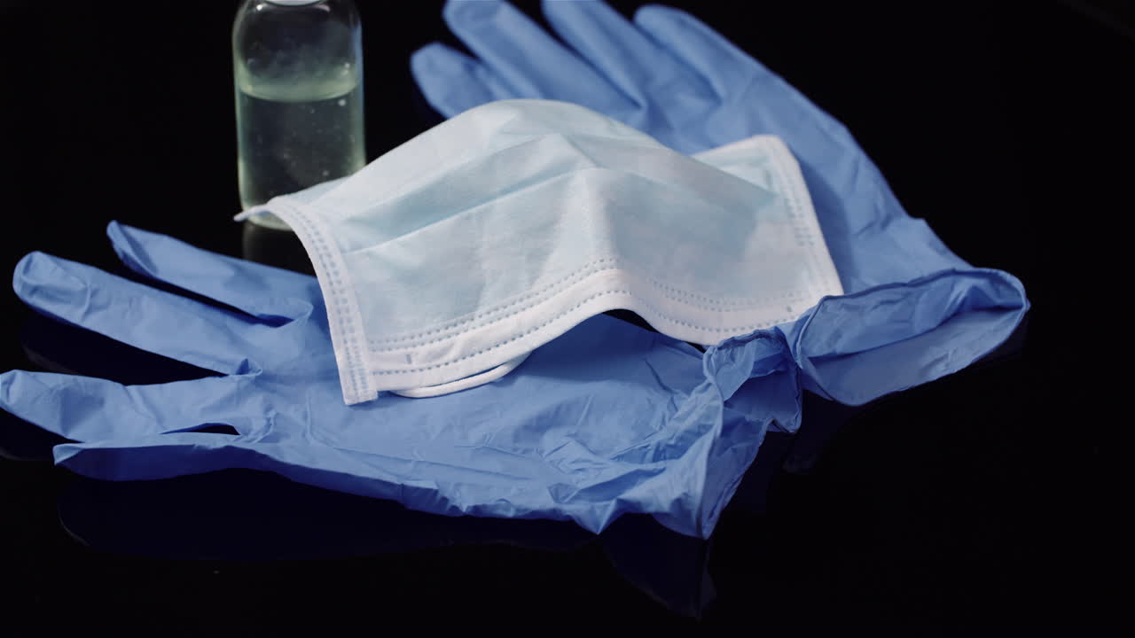 máscara protectora aislada sobre fondo negro máscara médica giratoria guantes protectores 1