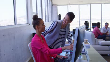 Beautiful-multi-ethnic-businesswomen-discussing-over-personal-computer-in-modern-office-4k