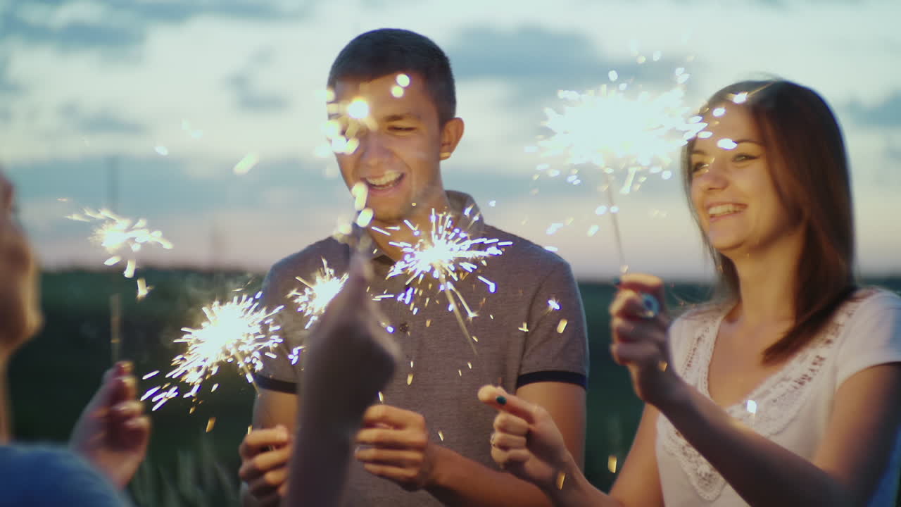 불꽃놀이를 손에 들고 저녁 파티에서 즐거운 시간을 보내는 친구들