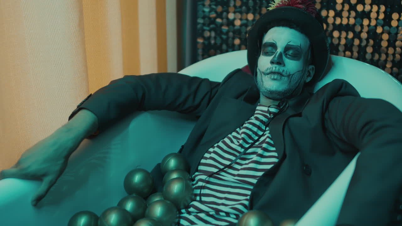 목욕탕에 있는 젊은 남자, 금색 공이 그 위에.