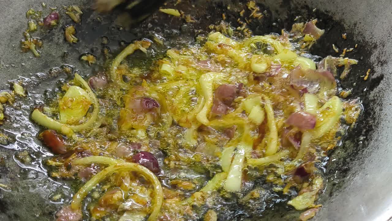 Sauterede løg, ansjoser og gurkemeje syder på en pande. Dette vigtige trin i Sydøstasien skaber en dyb aroma. Gurkemeje tilsættes for at skabe en smuk gylden-gul farve.