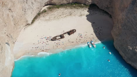 Vista-Aérea-De-Turistas-Relajándose-En-La-Playa-Navagio-En-Verano---Naufragio-En-Zakynthos,-Isla-Jónica,-Grecia