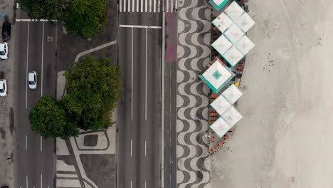 Luftbewegung-Von-Oben-Nach-Unten,-Die-Den-Strand-Und-Den-Boulevard-Von-Copacabana-Bei-Sonnenaufgang-Am-Frühen-Morgen-Mit-Ruhigen,-Fast-Leeren-Straßen-Zeigt