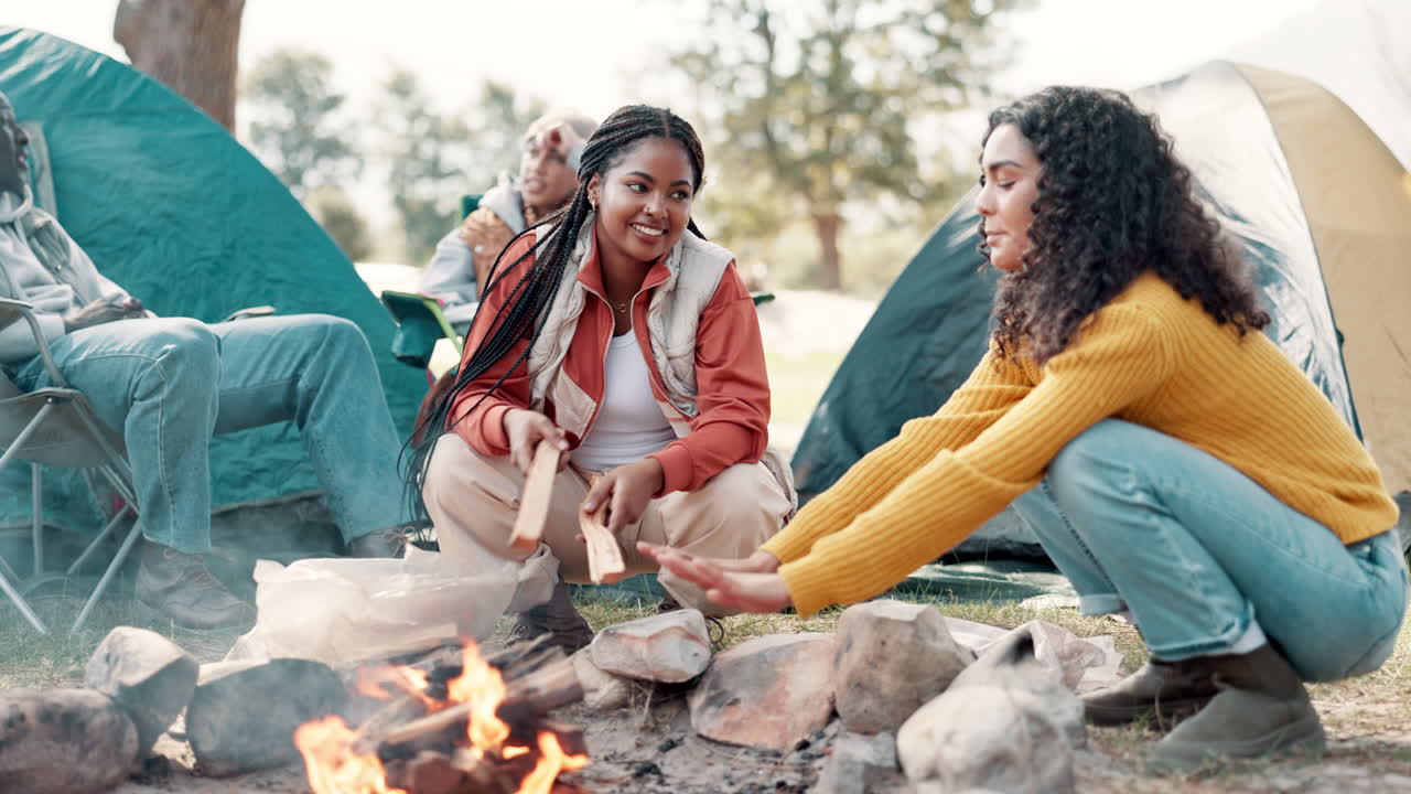 Friends camping around a campfire