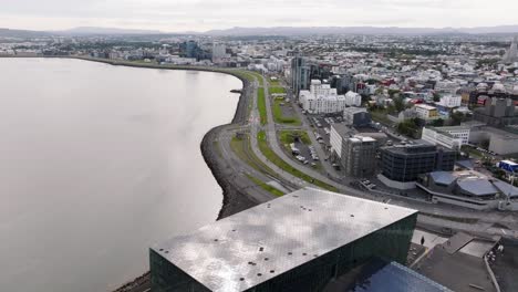 volando más allá de la sala de conciertos harpa revelando corredores de maratón en la calle, reykjavik
