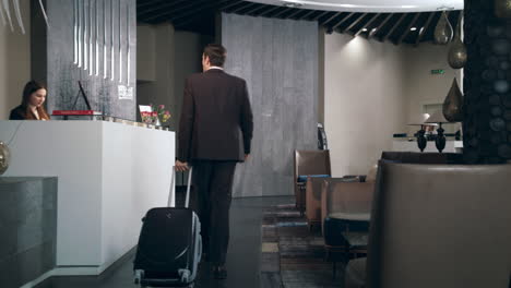 hombre de negocios con maleta de viaje llegando al hotel en vacaciones