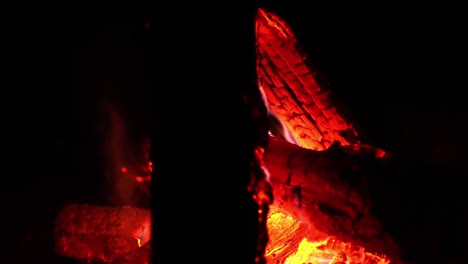 red yellow embers glow in slow motion as flames climb along bonfire