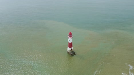 Flying-closely-around-Beachy-Head-Lighthouse-with-white-cliffs-and-sea-taken-on-the-background