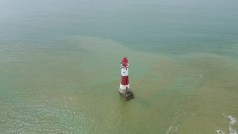 volando cerca del faro de la cabeza de la playa con acantilados blancos y mar tomado en el fondo