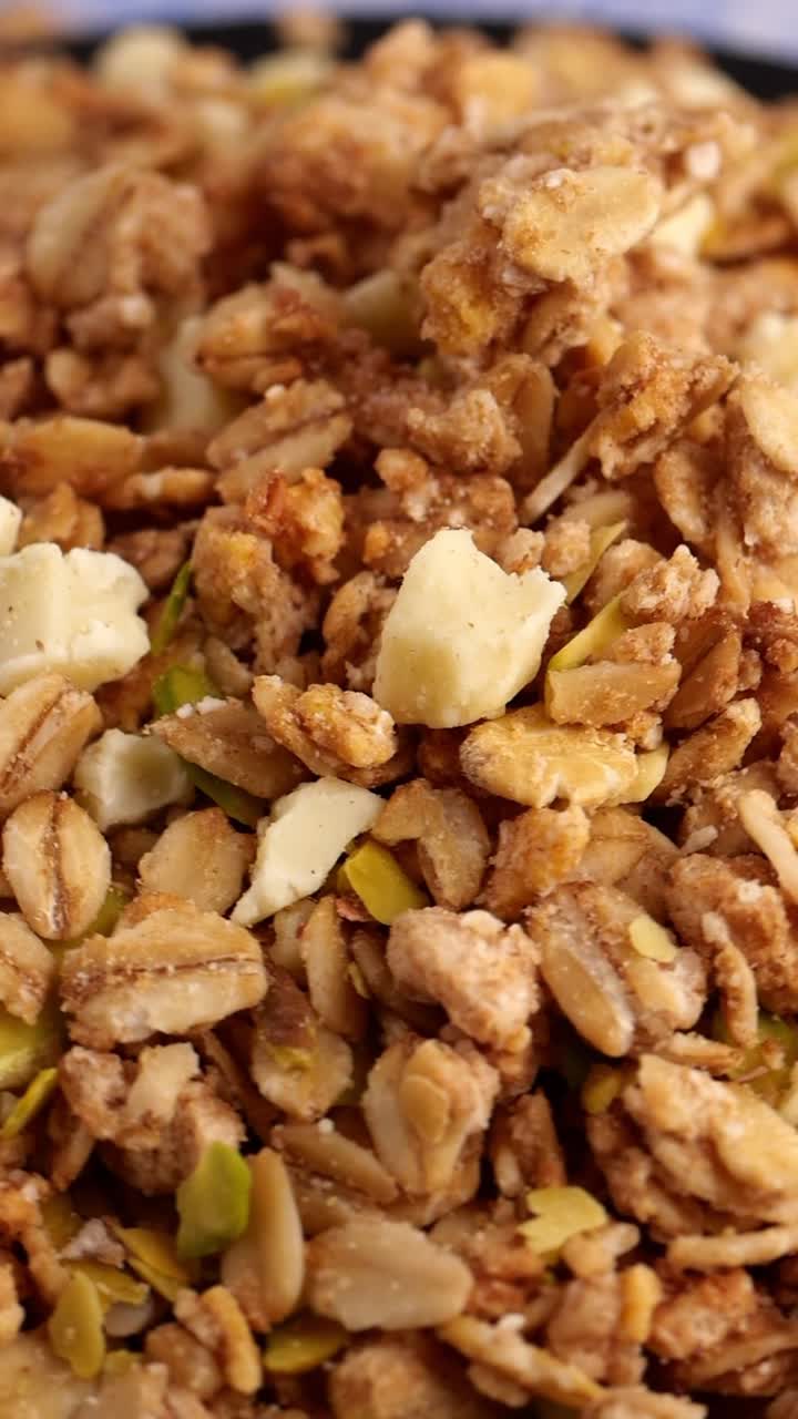 Primo piano in rotazione di deliziosa granola con avena e frutta secca.