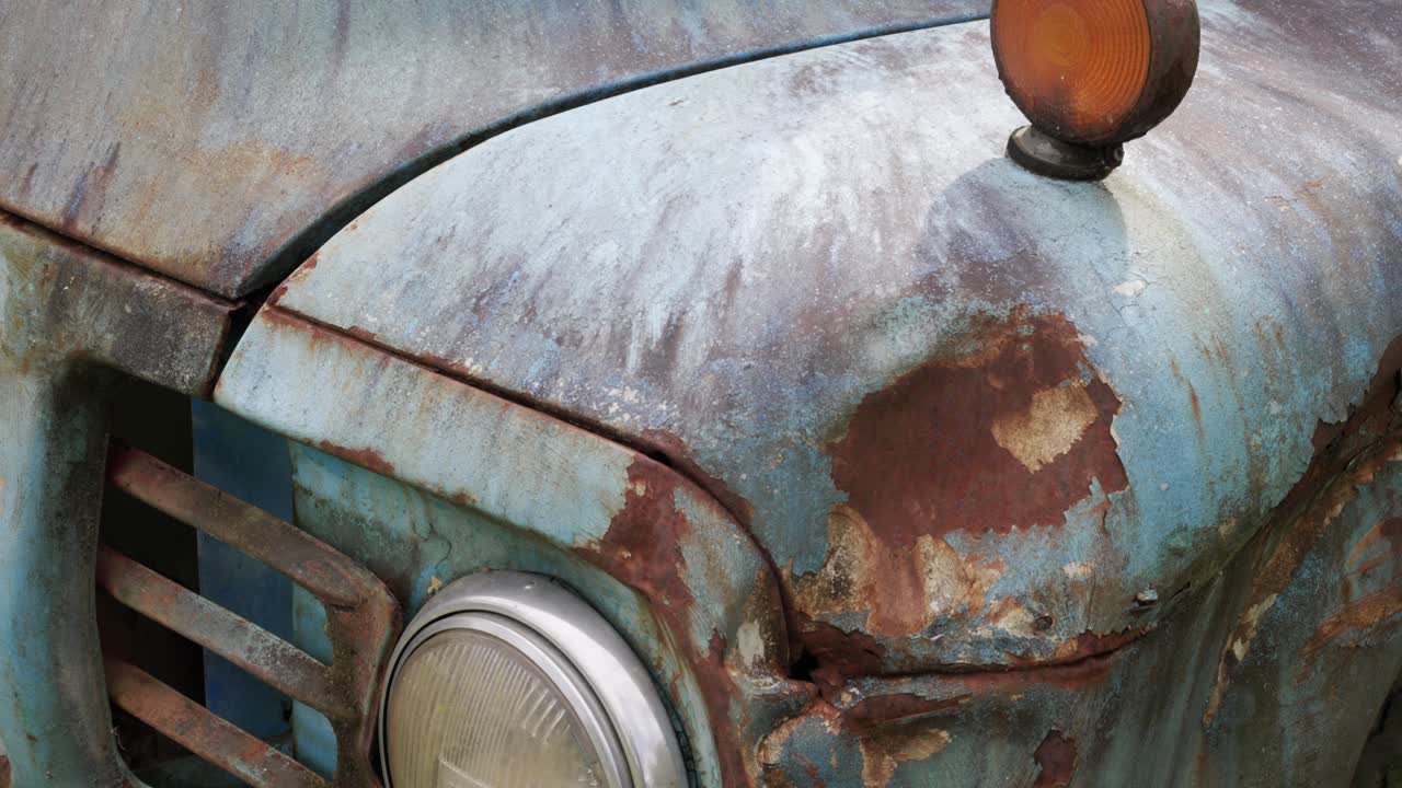Close up rusty vintage blue truck headlight with corrosion details
