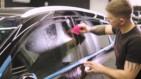 man covering car with vinyl polyurethane tape. films for the car. sticker protective film on the car