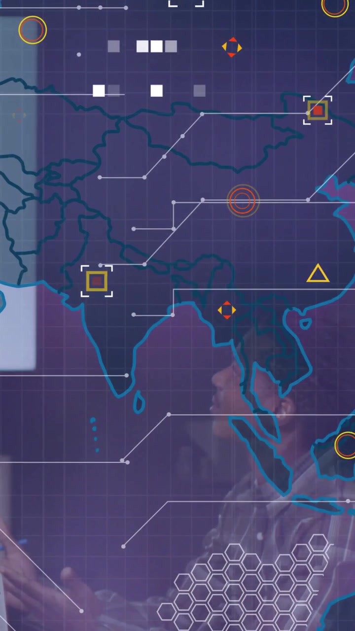 Vertical video: Plaid man gesturing in tech meeting while HUD map projecting team analyzing route
