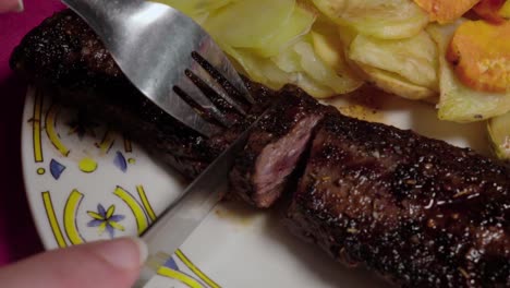primer plano, cortando un trozo de delicioso filete de ternera y sacándolo del marco