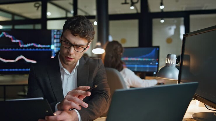 Investment broker analyzing data in evening office. Successful businessman work