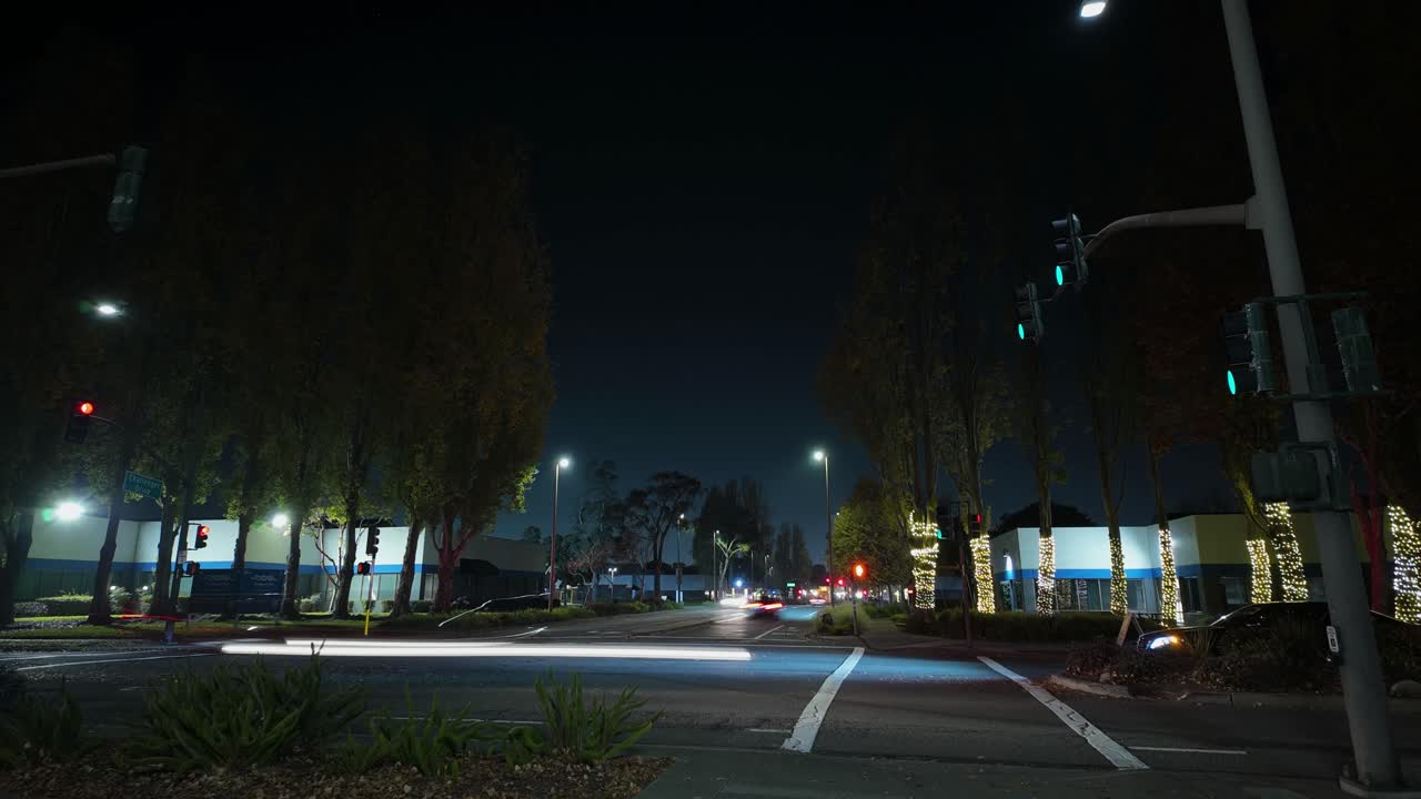 An evening time-lapse captures cars rolling through Marina Village, blending glowing headlights, leafy residential areas, and a steady flow of motion at night