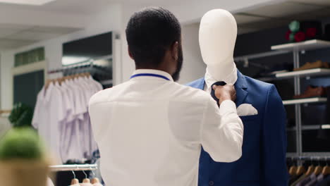 trabajador aprieta la corbata del maniquí blazer