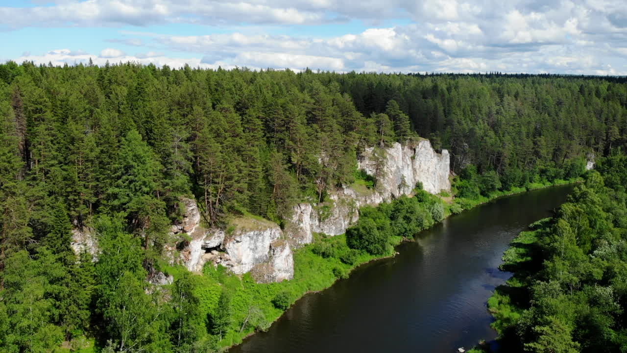 Aerial view of a river flowing through a forest with cliffs