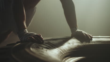 man doing tire push ups