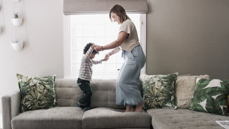 madre y hijo saltando en el sofá