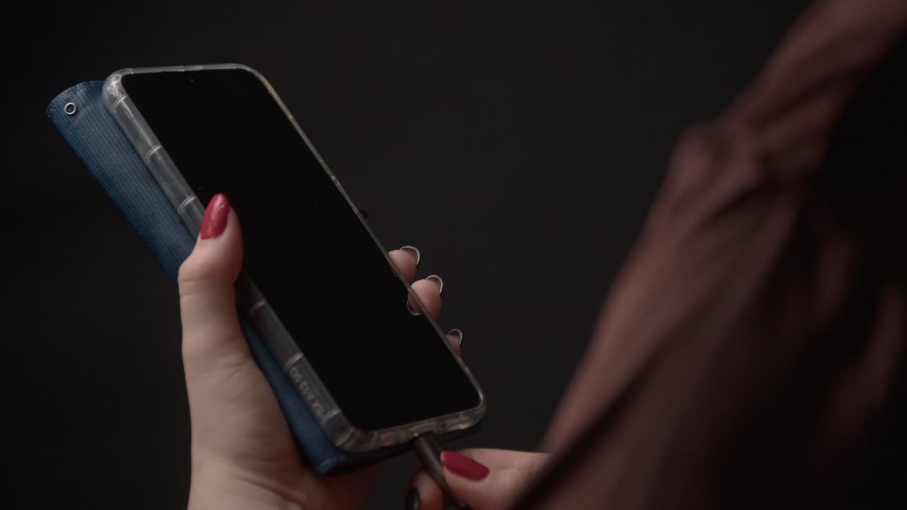 Detailed close-up shot of a smartphone in hand, ready to charge. The lighting is soft and atmospheric, enhancing the device's sleek design against a blurred background, highlighting everyday tech use