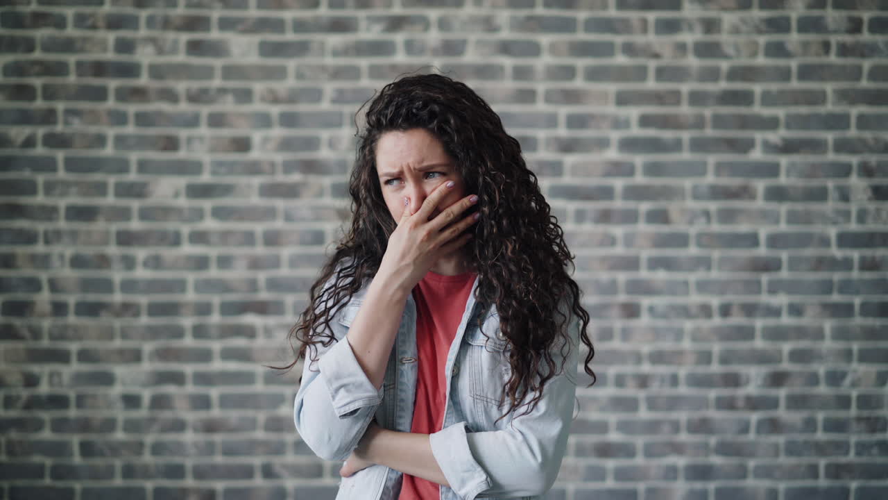 Woman looking concerned and covering mouth