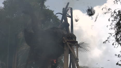 el humo y la ceniza se elevan desde la cabeza en llamas de un sarcófago en una ceremonia de cremación indonesia