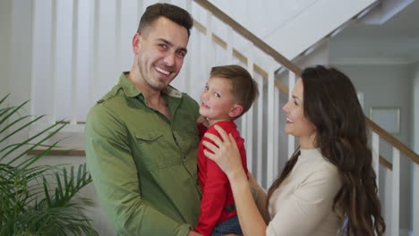retrato de una familia caucásica mirando a la cámara y sonriendo