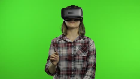 girl using vr app helmet to play simulation game. slide gestures. watching virtual reality 3d video