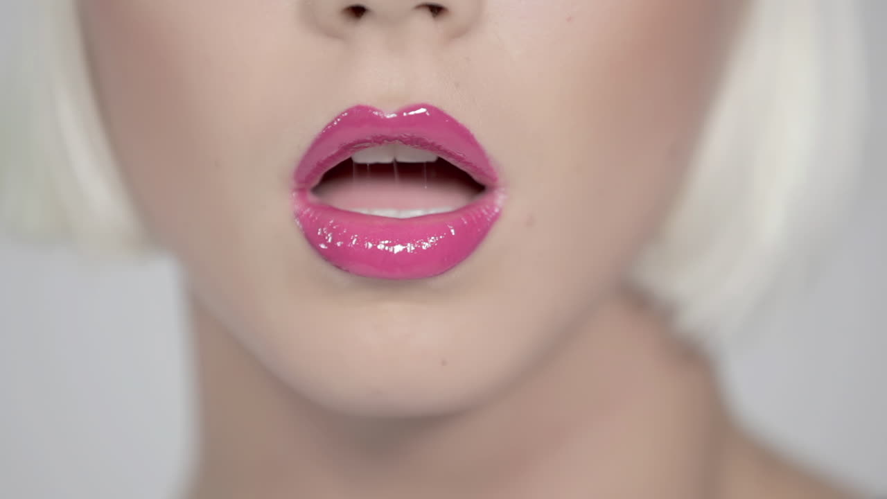 Closeup of pink lips blonde and white background