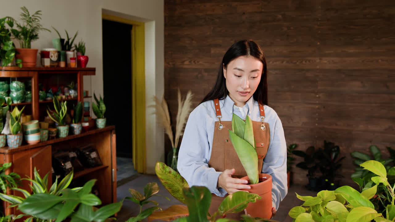 꽃 가게 에서 식물 을 파는 여자