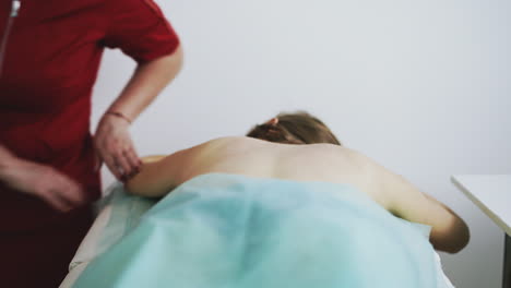 el doctor gordo hace un procedimiento de masaje clásico de la espalda de la chica.
