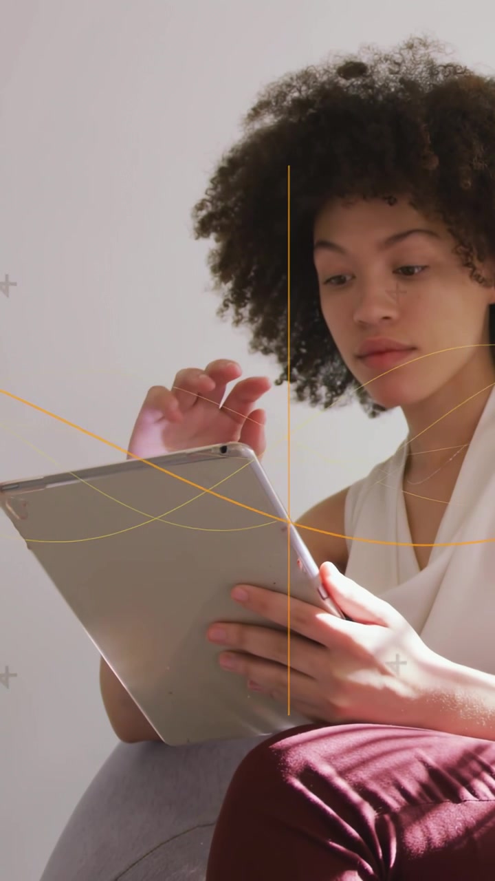 Video verticale: Donna che tocca un tablet a casa, generando linee grafiche che evidenziano il contenuto per l'edtech.